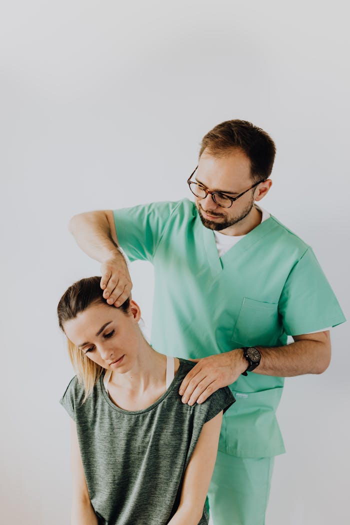 A chiropractor adjusts a patients neck to relieve pain indoors.